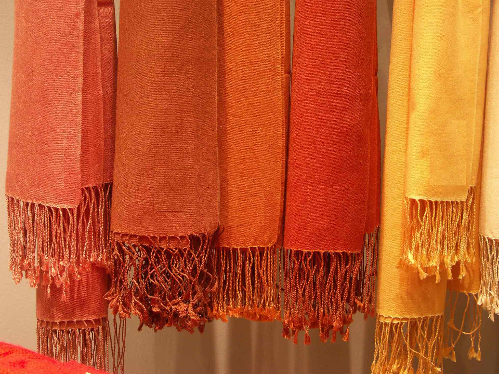 Six cashmere and silk shawls in warm rose, copper, red and gold colours