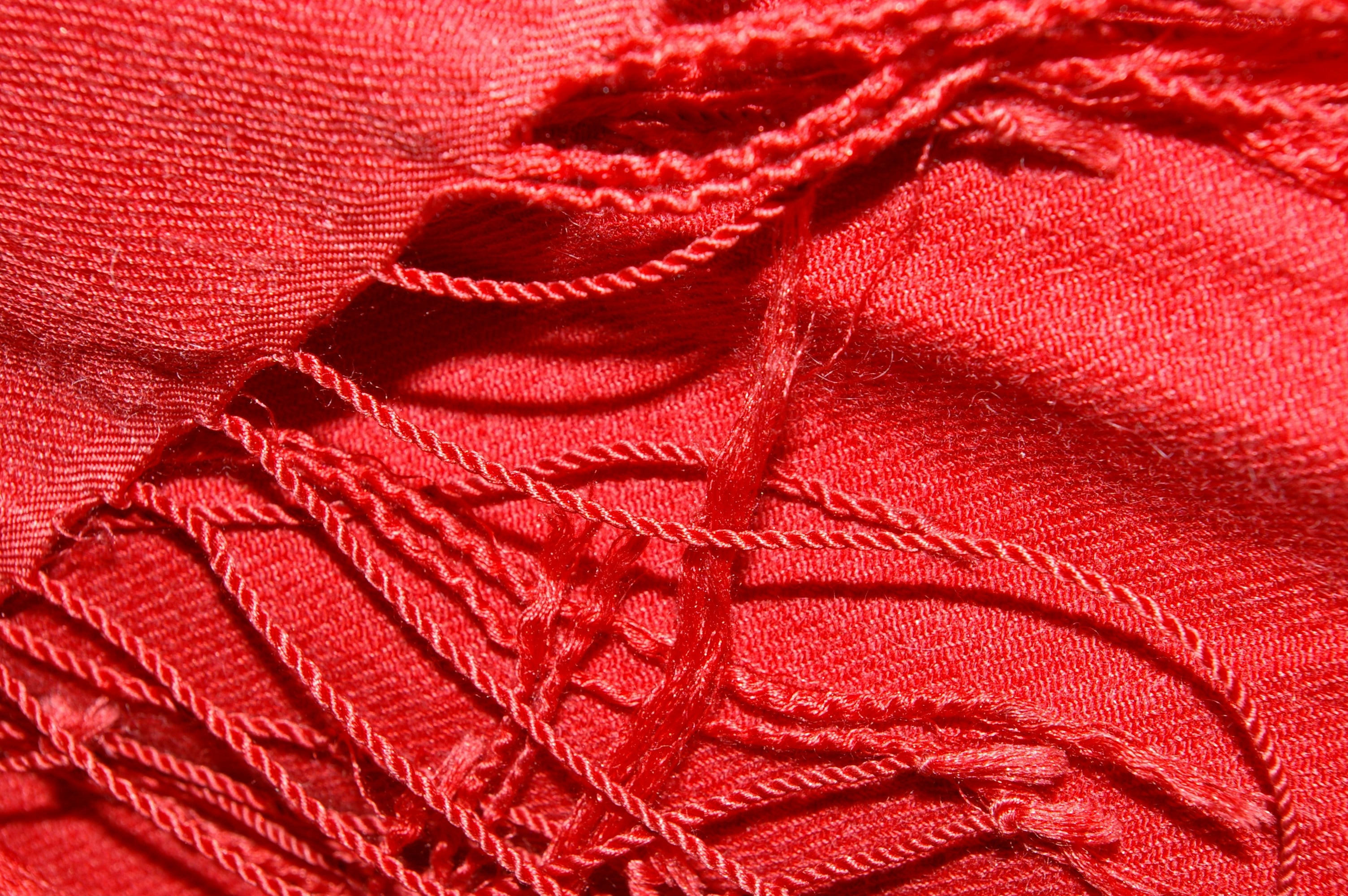 Close view of a crimson cashmere pashmina shawl with twisted fringe